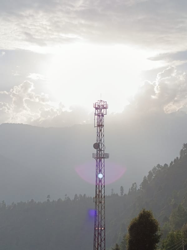 Cell tower and hazy mountain landscape, Damadi, India