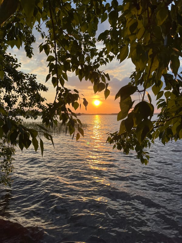 Two people watch sunset over water near Yekaterinburg