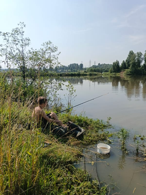 Quiet afternoon fishing and wading at a rural waterside