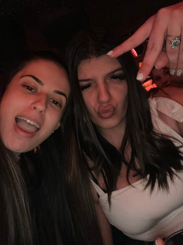 Two women pose casually together in evening photo