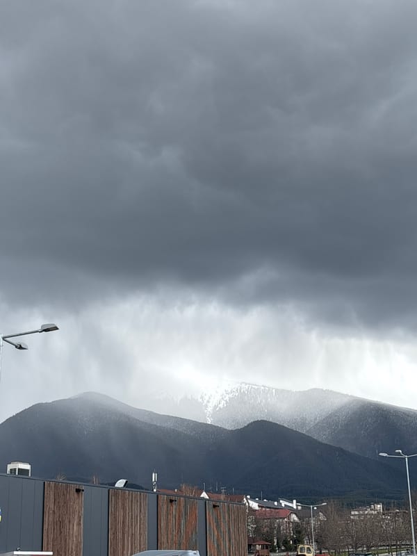 Overcast skies blanket Bansko's mountains and red-roofed buildings