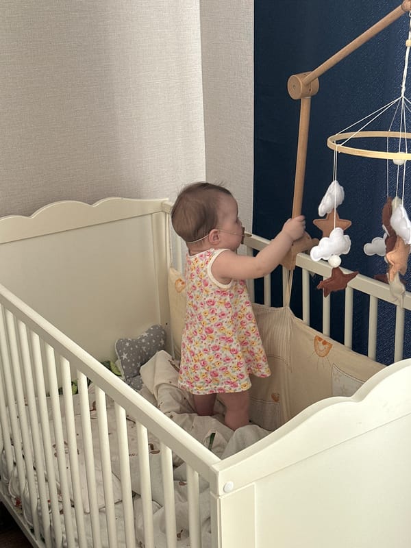 Baby reaches for mobile in crib in Подшивалово