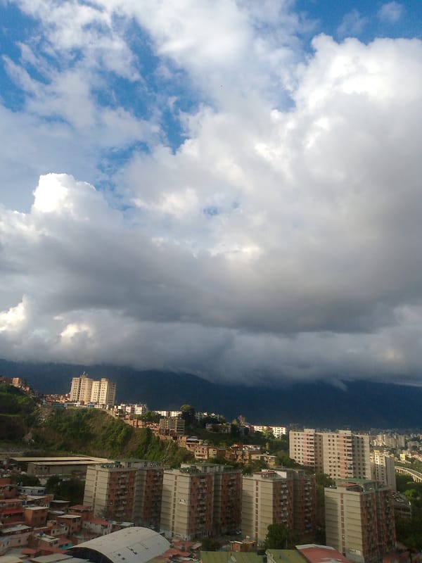 Caracas hillside neighborhoods under a dramatic overcast sky