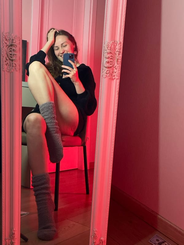 Person takes colored-light mirror selfies in Batumi room