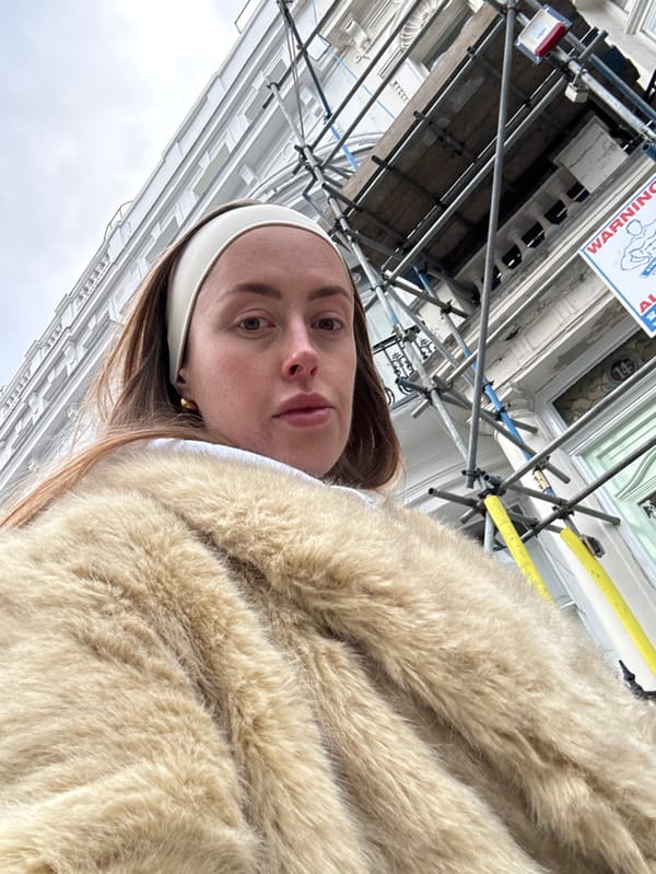Person in fur coat photographed walking London residential street