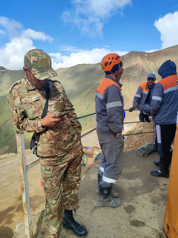 Construction activity and ground inspection in remote Kyrgyzstan mountains