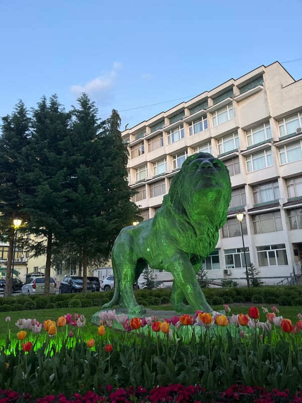 Evening park scene with lion statue, dogs in Pazardzhik