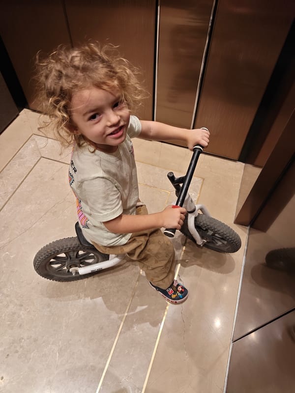 Toddler rides balance bike through Mumbai elevator and walkways
