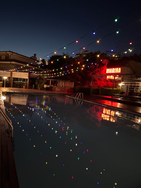 Colorful string lights over a poolside evening in Sveti Vlas