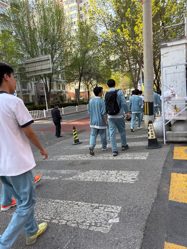 Students in matching tracksuits cross street in Beijing's Daxing District