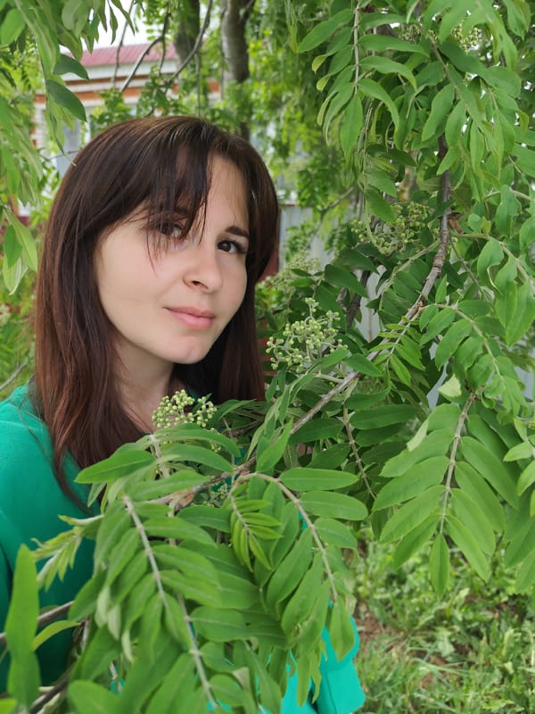 Woman photographed among spring foliage in Russian garden setting