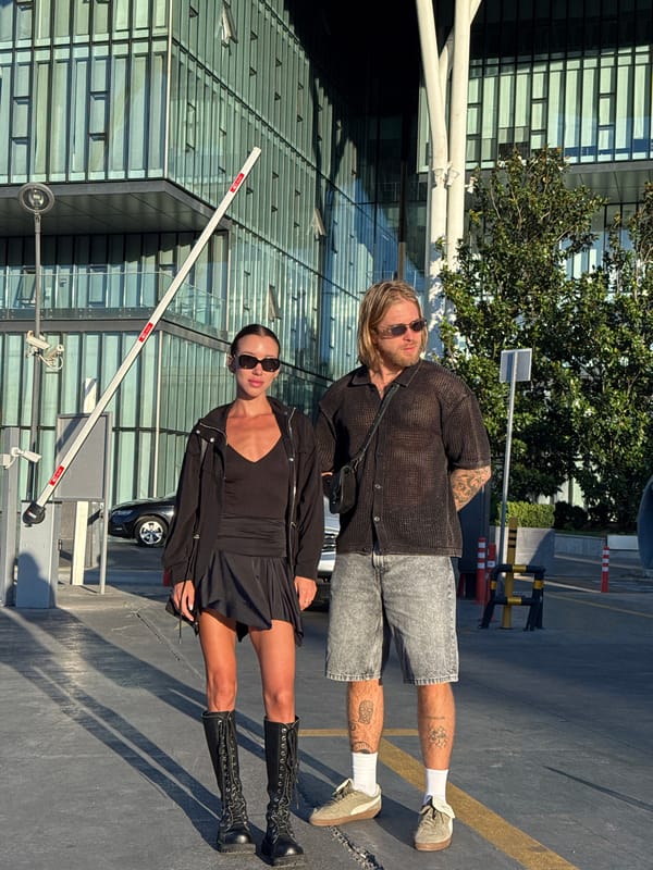 Candid moments near a glass building in Tbilisi at sunset