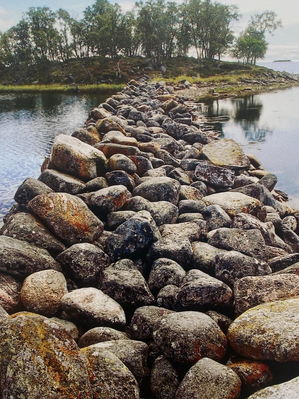 Adult and child rest by stone waterway embankment in Шебунино