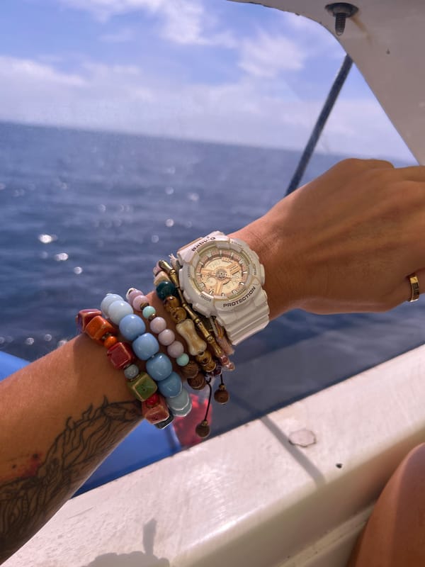 Person with beaded bracelets photographed on boat near Rawai