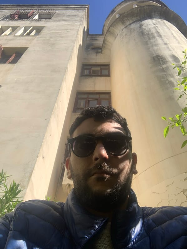 Man in blue jacket photographed near domed building in Meknes
