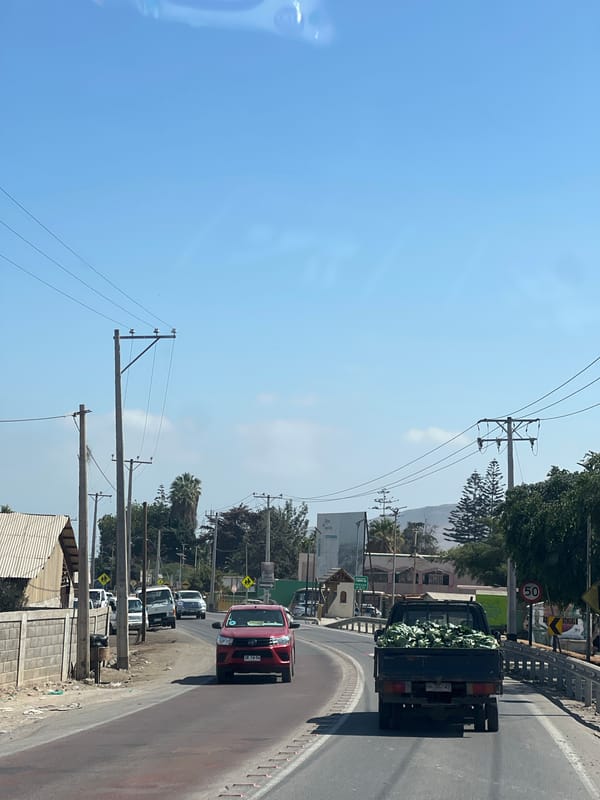 Vehicles spotted on sunny Arica street, truck carrying vegetables