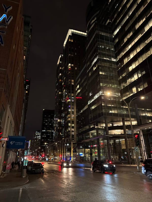 Wet Montreal streets reflect city lights during early morning hours