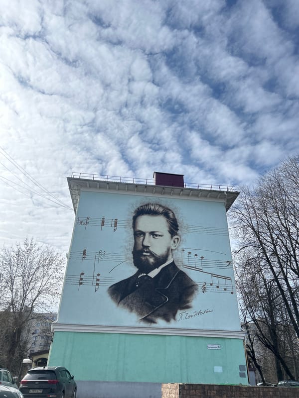 Woman photographed multiple times in Klin alongside Tchaikovsky mural