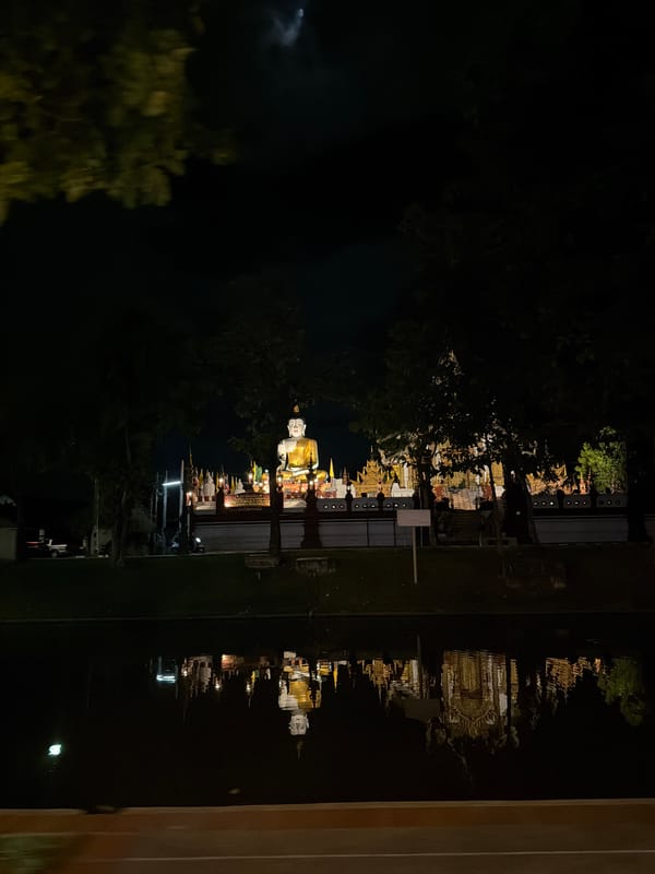 Illuminated golden Buddha statue at night in Chiang Mai
