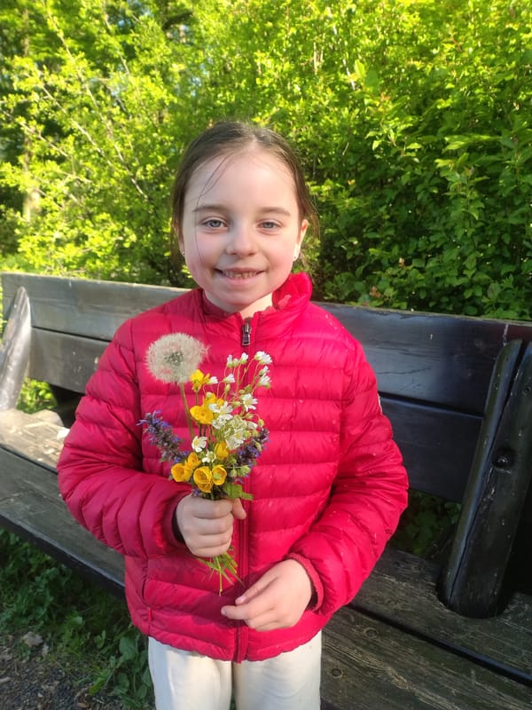 Girl enjoys wildflower bouquet in Luxembourg morning