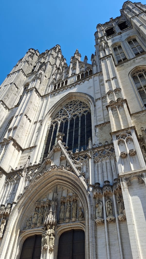 Inside a grand Gothic cathedral, statues, glass, and stone.