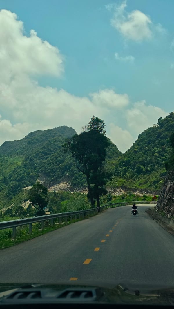 Motorcycle travels mountain road through northern Vietnam communes