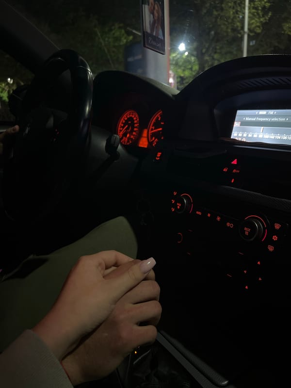 Couple holds hands inside BMW at night in Plovdiv