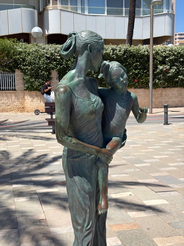 Woman walks beachfront promenade in sunny Alicante