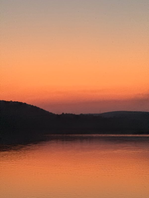 Sunset over a lake in Berezhany, playground on the shore