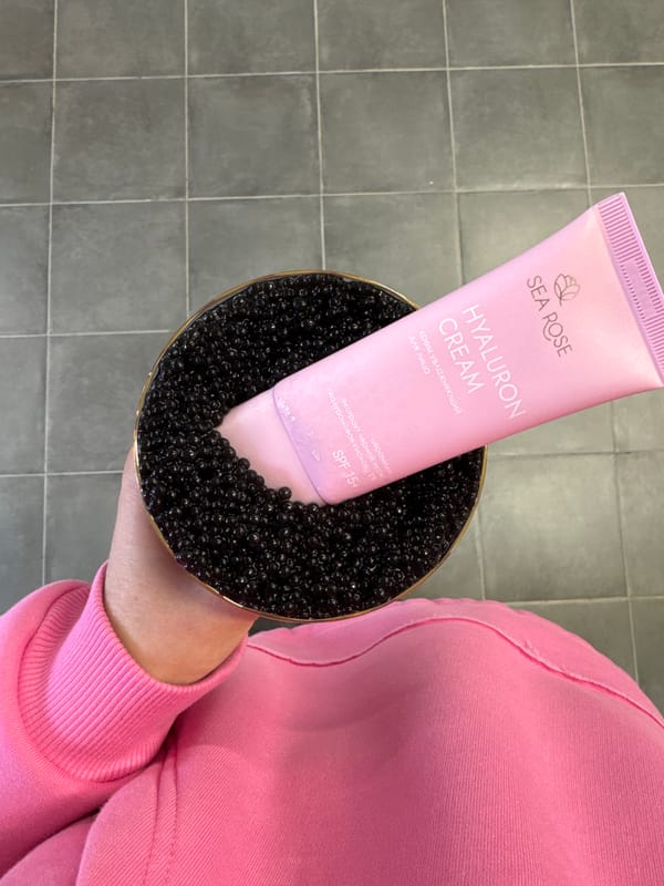 Person displays cosmetic cream in decorative dish with black beads