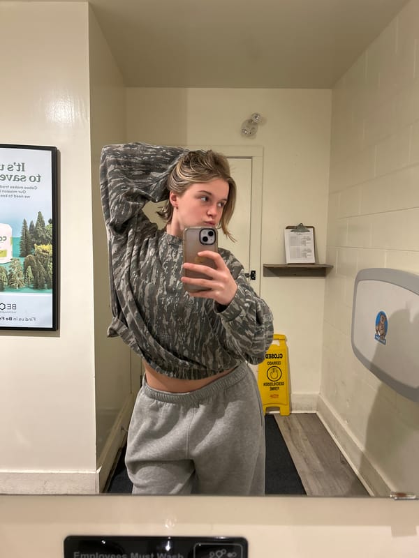 Young woman takes mirror selfie in Vancouver public restroom