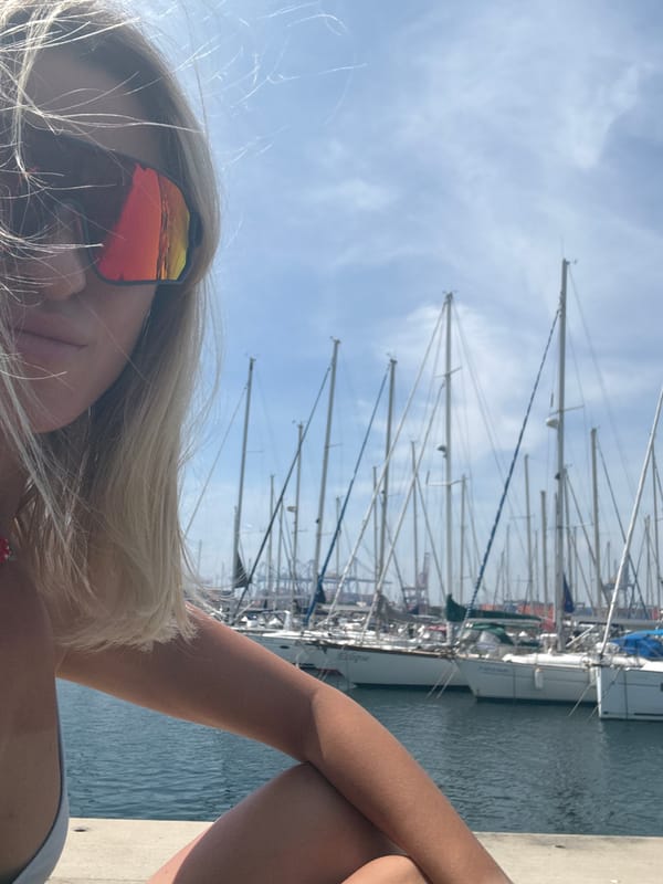 Person relaxes by Valencia marina on sunny morning