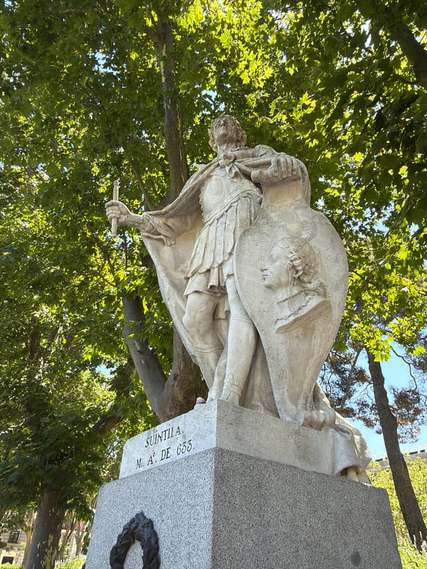 Historic stone statues in a sunny Madrid park