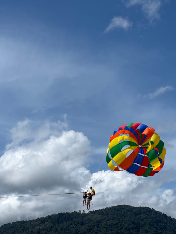 Parasailing and beach activity on a busy Patong morning