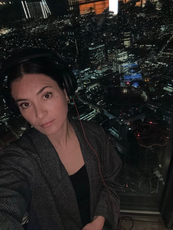 Woman in headphones observed against London night cityscape