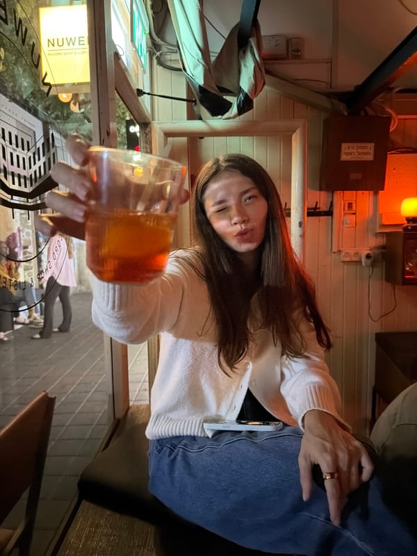 Woman raises glass in vintage bar setting