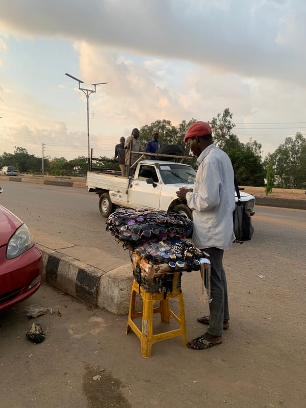 Street vendor sells accessories from stool in Gura Top