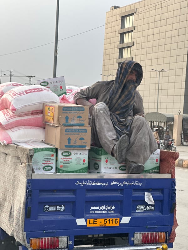 Man sits atop cargo truck in Quetta, Pakistan