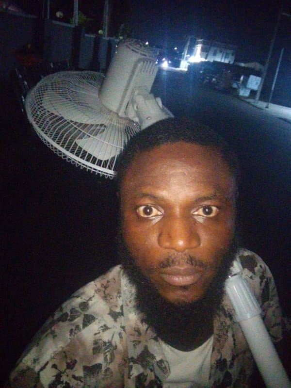 Man carries white fan through city streets at night