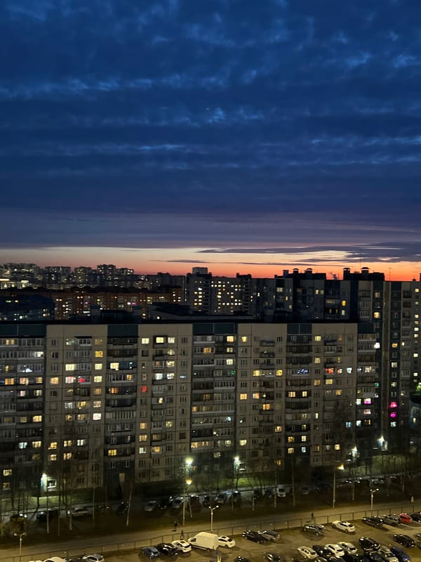 Evening lights illuminate Saint Petersburg apartment buildings at dusk