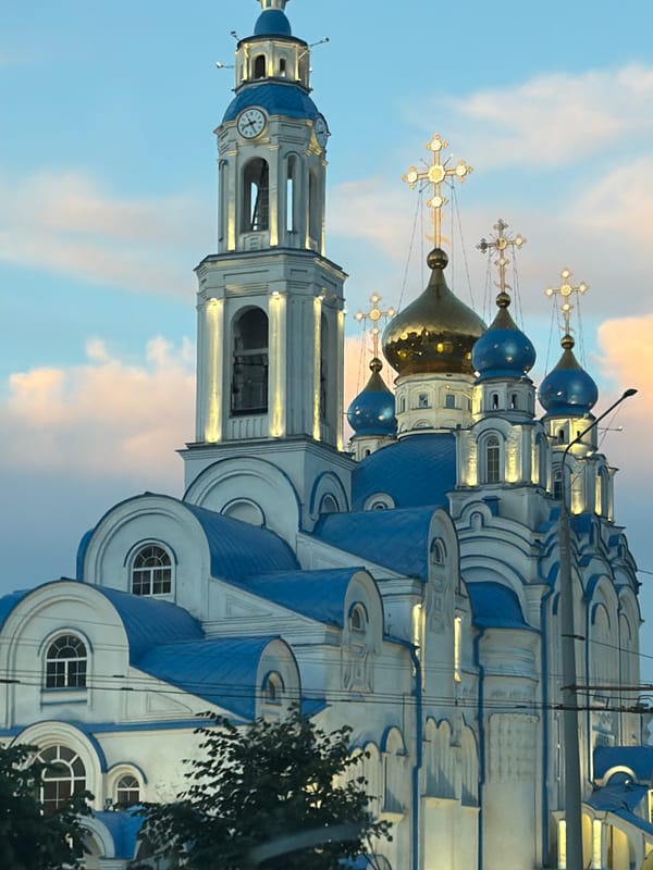Dusk traffic and city streets near a domed church
