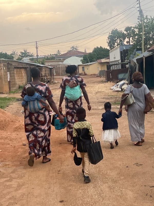 Women gather on dirt streets in Gura Top, Nigeria