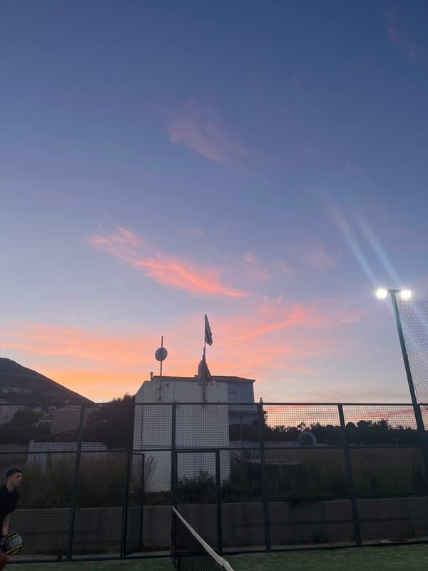 Evening paddle tennis match captured at Spanish coastal town