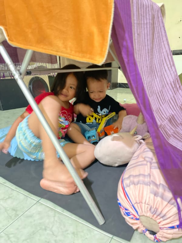 Children play in blanket fort during morning hours