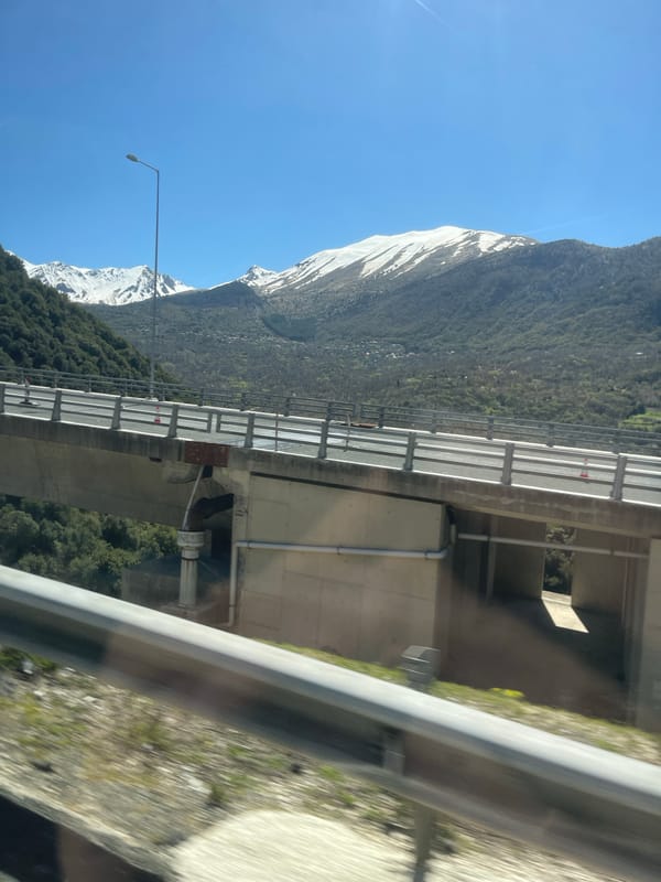 Snow-covered mountain viewed from highway overpass in Metsovo, Greece