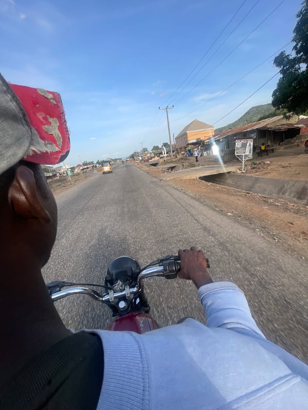 Motorcycle rider travels paved road in Lokoja, Nigeria