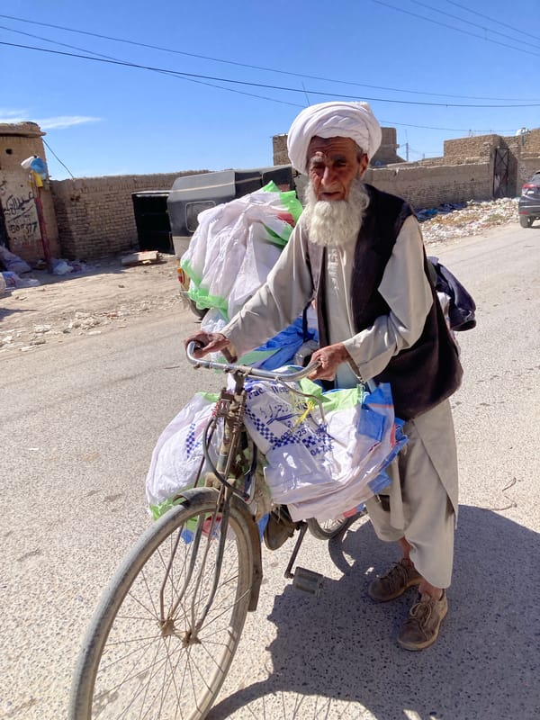 Elderly man cycles through Quetta streets in traditional dress