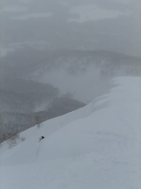 Heavy snowfall obscures lone figure on Niseko mountain slope