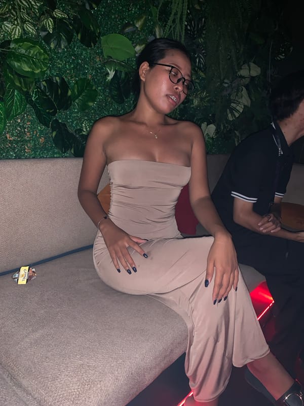 Woman relaxes on couch, nightclub activity in North Kuta