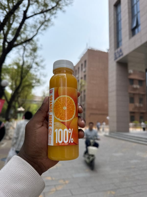 Orange juice bottle displayed against Beijing cityscape